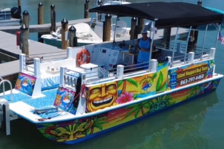 Colorful boat docked at marina with vibrant tropical artwork.