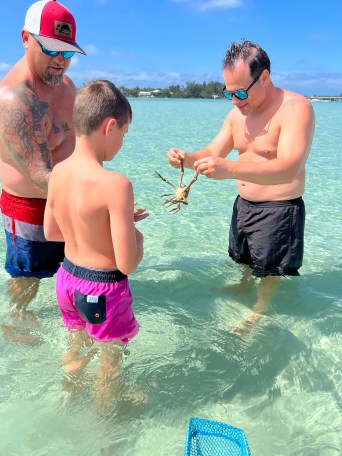 a young boy standing next to a body of water