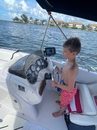 a boy sitting on a boat in the water