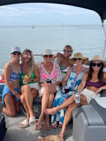 a group of people sitting in a boat on a body of water