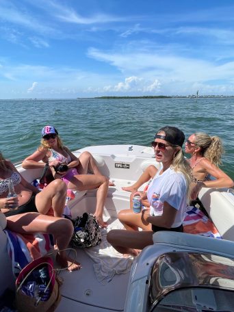 a group of people sitting in a boat on a body of water