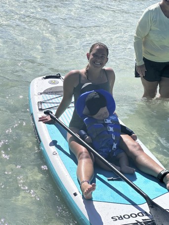 a man and woman sitting next to a body of water